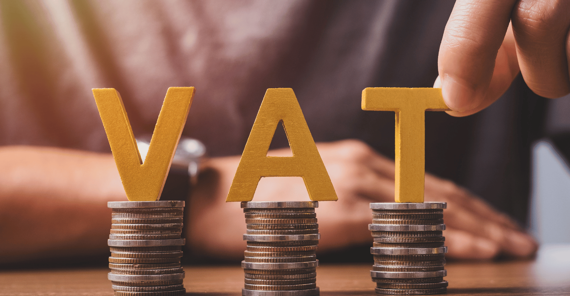 Obrazek przedstawiający podatek vat, litery vat są umieszczone nad monetami