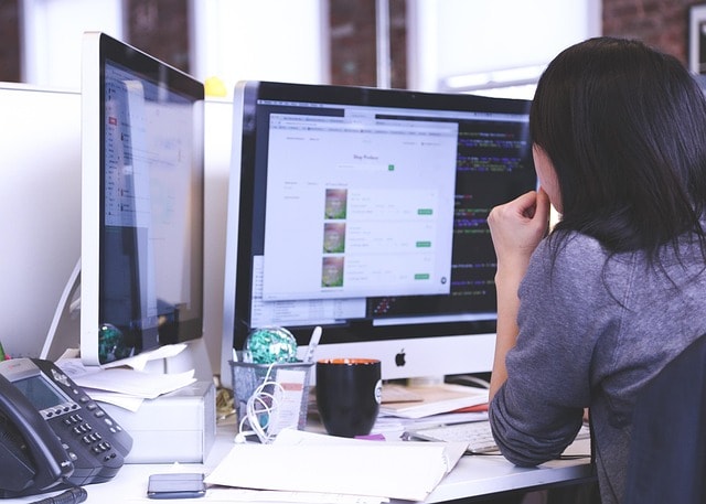 Startup małej firmy, na niej dziewczyna siedząca przed monitorem